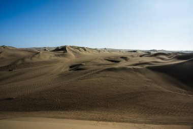 Ica Peru 'da mavi gökyüzü olan çöl çölündeki kum tepeleri.