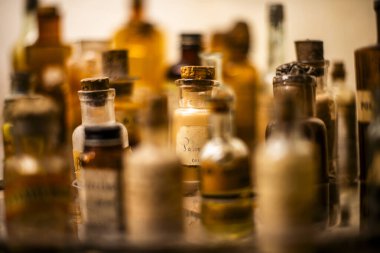 Peru 'nun dağlık bölgelerindeki Cuzco İnka şehrinde antik kahverengi yazıtlarla dolu vitrin şişelerinin arkasındaki eski ilaç şişeleri.