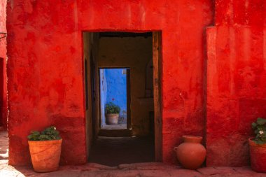 Peru 'daki Cusco İnka şehrindeki bir manastırın içindeki kırmızı ve mavi duvarlarda antik kapılar.
