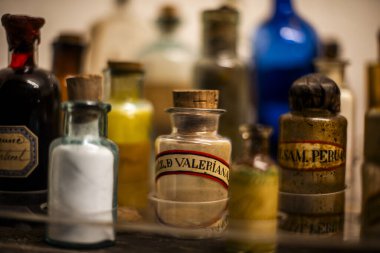 Peru 'nun dağlık bölgelerindeki Cuzco İnka şehrinde antik kahverengi yazıtlarla dolu vitrin şişelerinin arkasındaki eski ilaç şişeleri.