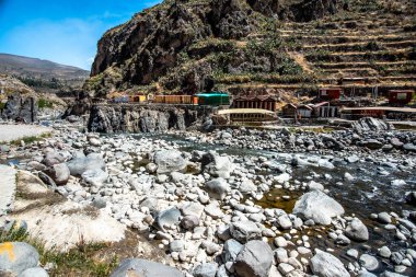 Peru 'nun çöl tepelerinde, Arequipa yakınlarındaki bir vadide sıcak su kaynakları ve And Dağları manzarası olan bir nehir.