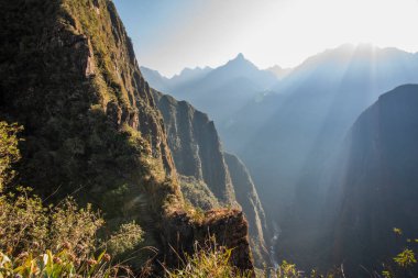 Peru 'nun güneyindeki Doğu Cordillera' nın arka planında And Dağları 'nın zirveleriyle ağaçların ve İnka harabelerinin arasında gün doğumu.