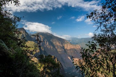 Peru 'nun güneyindeki Peru' nun güneyindeki Cordillera Doğu 'nun dağ zirveleri Peru And Dağları' ndaki tropik bitki örtüleriyle dolu derin vadi ve kanyonların arasında.