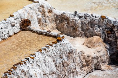 Dağ tuzunun ayrıntıları tuzlu beyaz tencereyle ve suyun kahverengisiyle birlikte Güney Amerika 'daki Peru' da buharlaşarak tuza dönüşüyor.