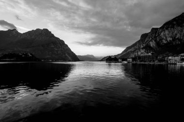 Sonbaharda Lecco Gölü 'nün sakin ve sakin sularıyla gün batımının olduğu bir akşam İtalya' nın Lecco kentindeki dağların arasında.