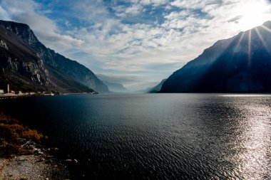 Sonbaharda Lecco Gölü 'nün sakin ve sakin sularıyla gün batımının olduğu bir akşam İtalya' nın Lecco kentindeki dağların arasında.