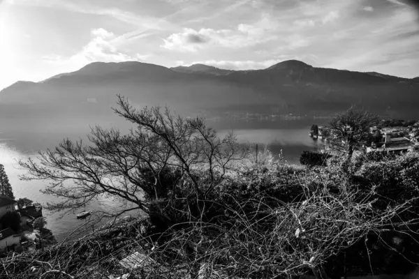 Sonbaharda Lecco Gölü 'nün sakin ve sakin sularıyla gün batımının olduğu bir akşam İtalya' nın Lecco kentindeki dağların arasında.