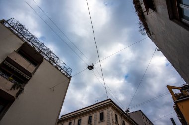İtalya 'da Milano sokaklarında gökyüzü ve elektrik kabloları olan pencere ve binaların geometrisi