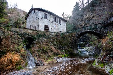 İtalya 'daki Como Gölü yakınlarındaki Varenna yakınlarındaki dağlık bir dere kıyısında terk edilmiş eski bir değirmen.