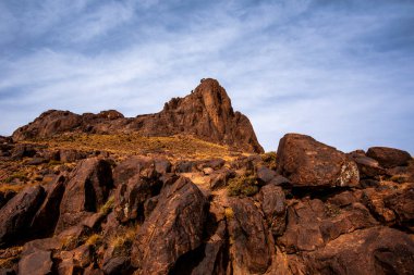 Fas 'taki Marakeş' te Ouarzazate yakınlarında, Jebel Saghro 'daki Berber toprakları arasında çöl vadileri olan Fas Atlası' nın dağ zirvelerinin ve kaya oluşumlarının görüntüsü.