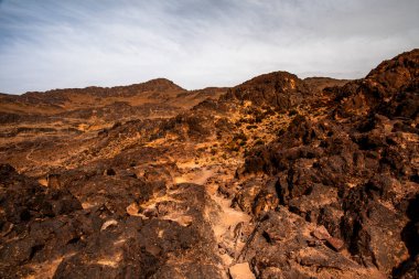 close up of rocks and rock formations among the peaks of the Moroccan Atlas between desert valleys and Berber lands in Jebel Saghro near Ouarzazate in Marrakech Morocco clipart