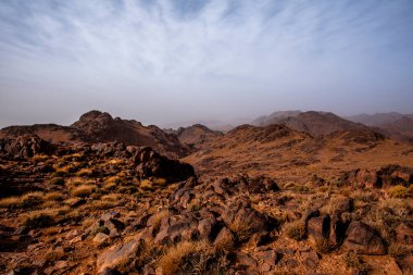 Fas 'ta Marakeş' te Ouarzazate yakınlarında Jebel Saghro 'daki Fas Atlası' nın zirveleri arasındaki Berber kervanlarının ve kayaların arasındaki çöl vadileri.