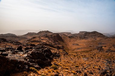 Fas 'ta Marakeş' te Ouarzazate yakınlarında Jebel Saghro 'daki Fas Atlası' nın zirveleri arasındaki Berber kervanlarının ve kayaların arasındaki çöl vadileri.