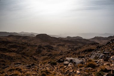 Fas 'ta Marakeş' te Ouarzazate yakınlarında Jebel Saghro 'daki Fas Atlası' nın zirveleri arasındaki Berber kervanlarının ve kayaların arasındaki çöl vadileri.