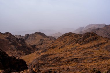 Fas 'ta Marakeş' te Ouarzazate yakınlarında Jebel Saghro 'daki Fas Atlası' nın zirveleri arasındaki Berber kervanlarının ve kayaların arasındaki çöl vadileri.
