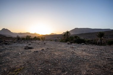 Fas 'ta Jebel Saghro' nun kayaları arasında şafak vakti Marakeş yakınlarındaki Atlas 'ın Fas kanyonları görülüyor. Güneş, Ourzazate ilindeki Berber bölgelerindeki antik kayaların arasından yükseliyor.