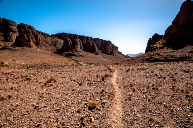 Fas 'ın Fas Atlas Berberi kervanı güzergahındaki Jebel Saghro' nun kurak tepeleri arasındaki beyaz yol Ourzazate 'nin antik yolları Berber çobanlarının Fas' ın Marakeş yakınlarındaki yolları.