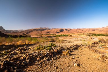 Fas 'ın Fas Atlas Berberi kervanı güzergahındaki Jebel Saghro' nun kurak tepeleri arasındaki beyaz yol Ourzazate 'nin antik yolları Berber çobanlarının Fas' ın Marakeş yakınlarındaki yolları.