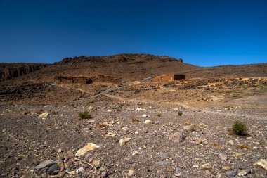 Fas 'ın Fas Atlas Berberi kervanı güzergahındaki Jebel Saghro' nun kurak tepeleri arasındaki beyaz yol Ourzazate 'nin antik yolları Berber çobanlarının Fas' ın Marakeş yakınlarındaki yolları.
