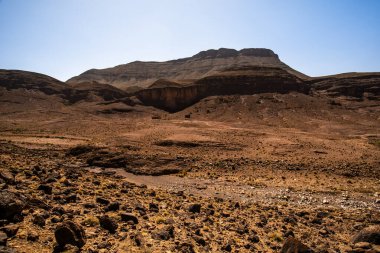 panorama of volcanic mountains and plains and plateaus the peaks and rocks of the south atlas morocco on the atlas between Bab N Ali and Jebel Saghro near Marrakesh and Ouarzazate in Morocco clipart