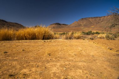 Handour Nehri 'nin kurak nehir yatağı dağlar arasında Fas' ın Ouarzazate yakınlarındaki Berber köyleri arasındaki Handour vadisinde Fas Atlası 'nın çölleşmesiyle kavrulmuş.