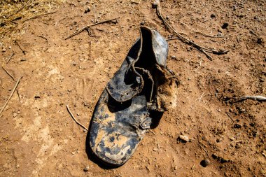 Eski kırık deri ayakkabı Ouarzazate Fas yakınlarındaki Fas Atlası 'nın taşlarının arasına bırakılmış.