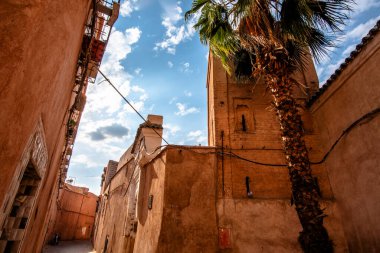 İki kırsal sandalye hasır ve bir ahşap yan yana, yosunlu beton bir yüzey üzerindeki eski dokulu bir duvara karşı, klasik ve kırsal atmosferi olan sessiz, nostaljik bir açık hava manzarası.