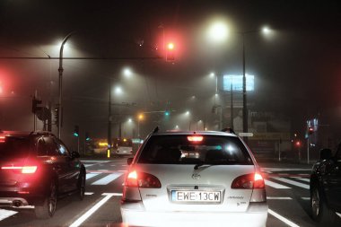 Lublin, Polonya, 1 Kasım 2022. Sisli sonbahar gecelerinde trafikte sis ışıkları açık olan arabalar.