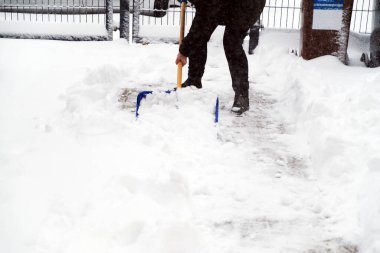 Kar fırtınası sırasında kar kürüyen kadın
