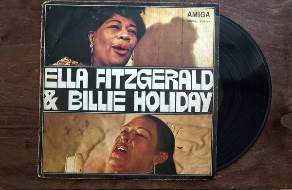 Lublin, Poland. 18 January 2023. Ella Fitzgerald and Billie Holiday vinyl album cover on dark wooden table.