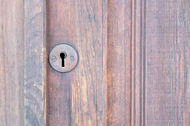 close up of old heyhole in locked wooden door - concept photo