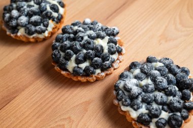 Tahta masada servis edilen taze yaban mersinli tart. Lezzetli yaz tatlısı.