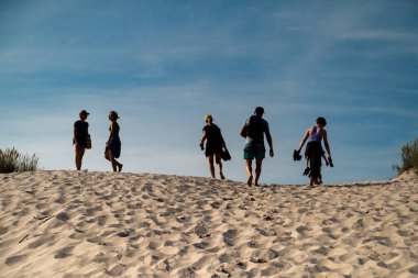 Leba, Polonya 25 Ağustos 2023. Slowinski Ulusal Parkı 'nda kum tepesine tırmanan turistler