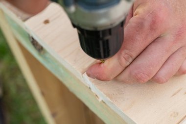 Tahta bir tahtayı vida tabancasıyla ahşap bir çerçeveye vidalayarak basit bir masayı diy projesi yapmak.