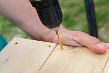 Tahta bir tahtayı vida tabancasıyla ahşap bir çerçeveye vidalayarak basit bir masayı diy projesi yapmak.