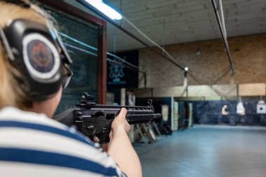 Kadın atış poligonuna silahla nişan alıyor.