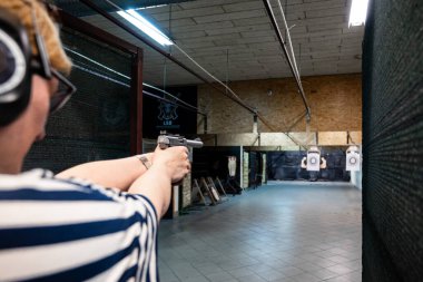 Kadın atış poligonuna silahla nişan alıyor.