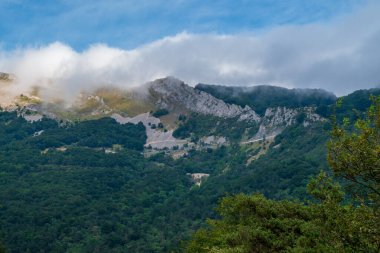 Vercors 'ta, Fransa' da Alpler öncesi bölgede, dağların tepeleri ve beyaz bulutların mavi gökyüzüne karşı güzel bir manzarası.