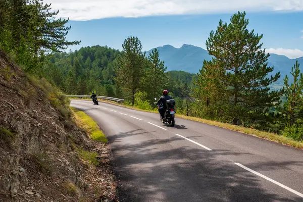 Fransa 'da Vercors Dağları' nda bir yolda motosiklet süren iki adam)