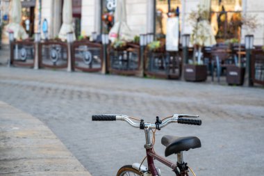 Eski Cracow şehrinin tarihi kaldırımlı caddesinde park edilmiş eski bir bisiklet.