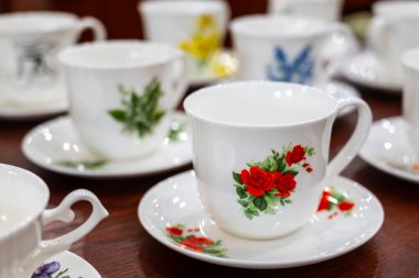 Cmielow, Polonya, 29.12.2024, AS Cmielow fabrikasında üretilen renkli çiçek desenli beyaz porselen bardak ve tabaklar.