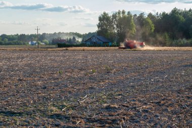 Kırmızı bir biçerdöver yaz akşamları tarla sürüyor.