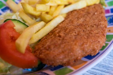 Tipik İngiliz yemeklerine yakın çekim - balık ve patates kızartması renkli bir tabakta Inn Gibraltar, İngiltere 'de servis edilir.