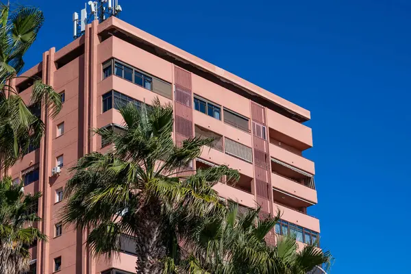 Malaga, Costa del Sol, İspanya, 29 Aralık 2024, Akdeniz manzaralı kule bloğu ve açık mavi gökyüzüne karşı palmiye ağaçları