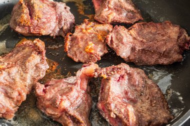 Yağ ile kızartılmış un serpiştirilmiş birkaç parça baharatlı sığır eti.