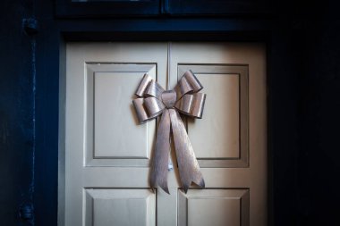 Yılbaşı bej renkli kurdele eski bir kapıda.