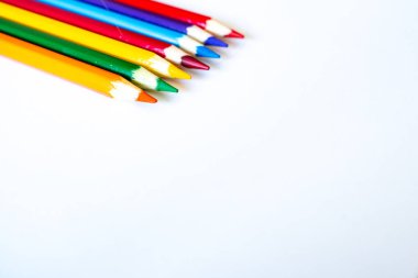 Bir grup renkli kalem boş beyaz kağıt üzerinde övgü topladı