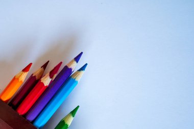 Bir grup renkli kalem boş beyaz kağıt üzerinde övgü topladı