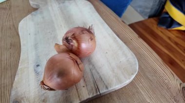 Bıçakla çiğ soğan soyan bir kadın.