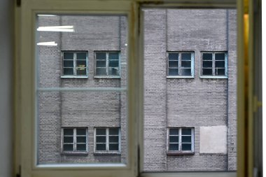 Gri bir duvar ve eski terk edilmiş bir sanayi binasının pencereleri - desenli arka plan fotoğrafı